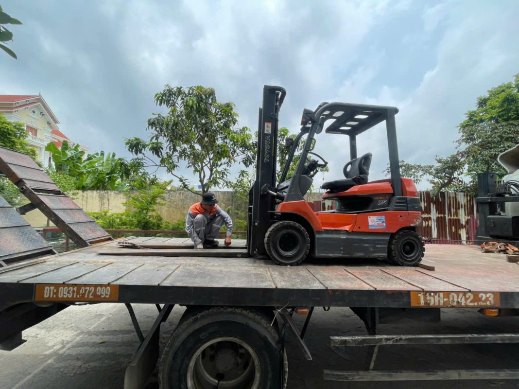 Xe nâng điện Toyota model 7FB25 được cẩu và hạ xuống an toàn từ xe tải chuyên dụng ngay tại nhà máy Hải Phòng, sẵn sàng đưa vào vận hành. Xe sơn zin, nội thất cabin sạch sẽ như mới, khung nâng chắc chắn