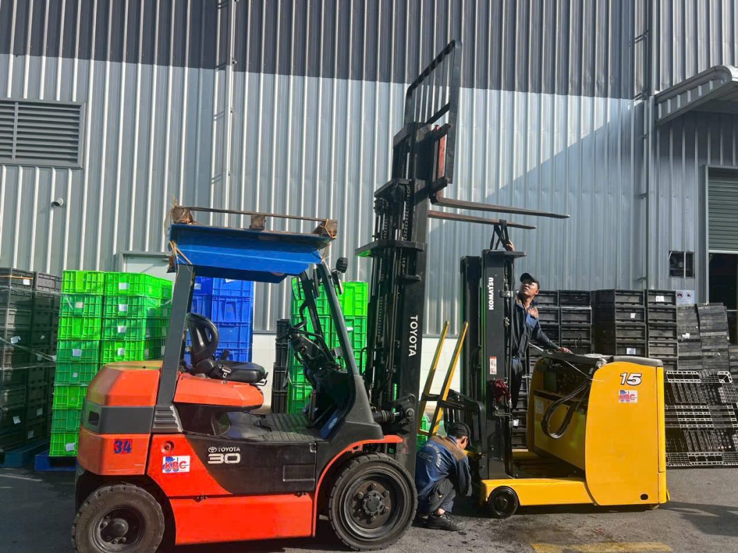 Hình ảnh bàn giao xe nâng điện reach truck Komatsu 1.5 tấn tại kho hàng trong KCN VSIP Hải Phòng, xe đang nâng hàng trên kệ cao.